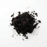 Close-up texture of fine, dark purple Herb & Honey Acai Berry Powder on a clean white background.
