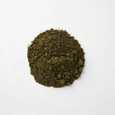 Close-up of a pile of fine, dark green 100% pure Brazilian Graviola Soursop leaf powder by Herb & Honey on a white background.