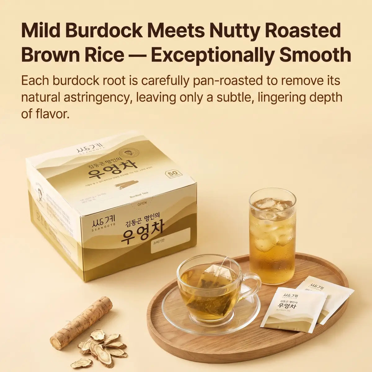 A boxed herbal tea product labeled in Korean sits on a beige background beside a glass of iced tea, a teacup with tea bags, loose burdock roots, and a wooden tray. Large headline text at the top reads, 'Mild Burdock Meets Nutty Roasted Brown Rice — Exceptionally Smooth.
