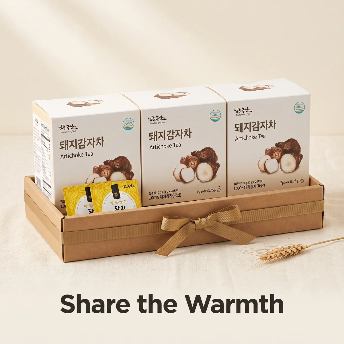 Three boxes of Korean sunchoke tea in a kraft gift tray with a ribbon