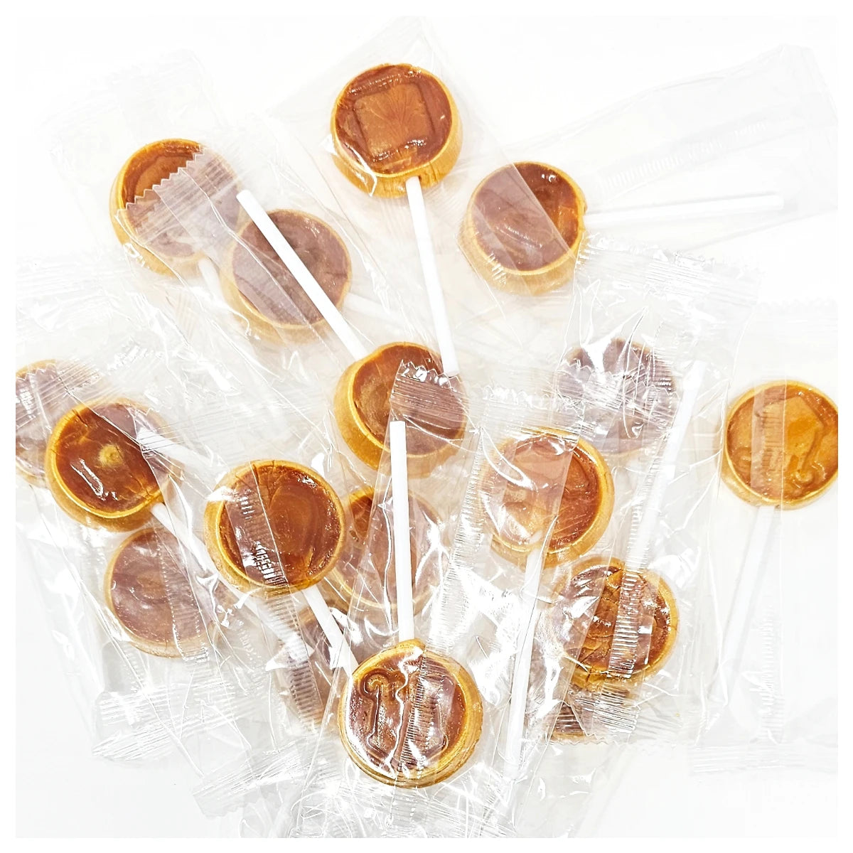 Close-up of unwrapped Korean Dalgona candy sticks showing the golden honeycomb texture and embossed shapes.
