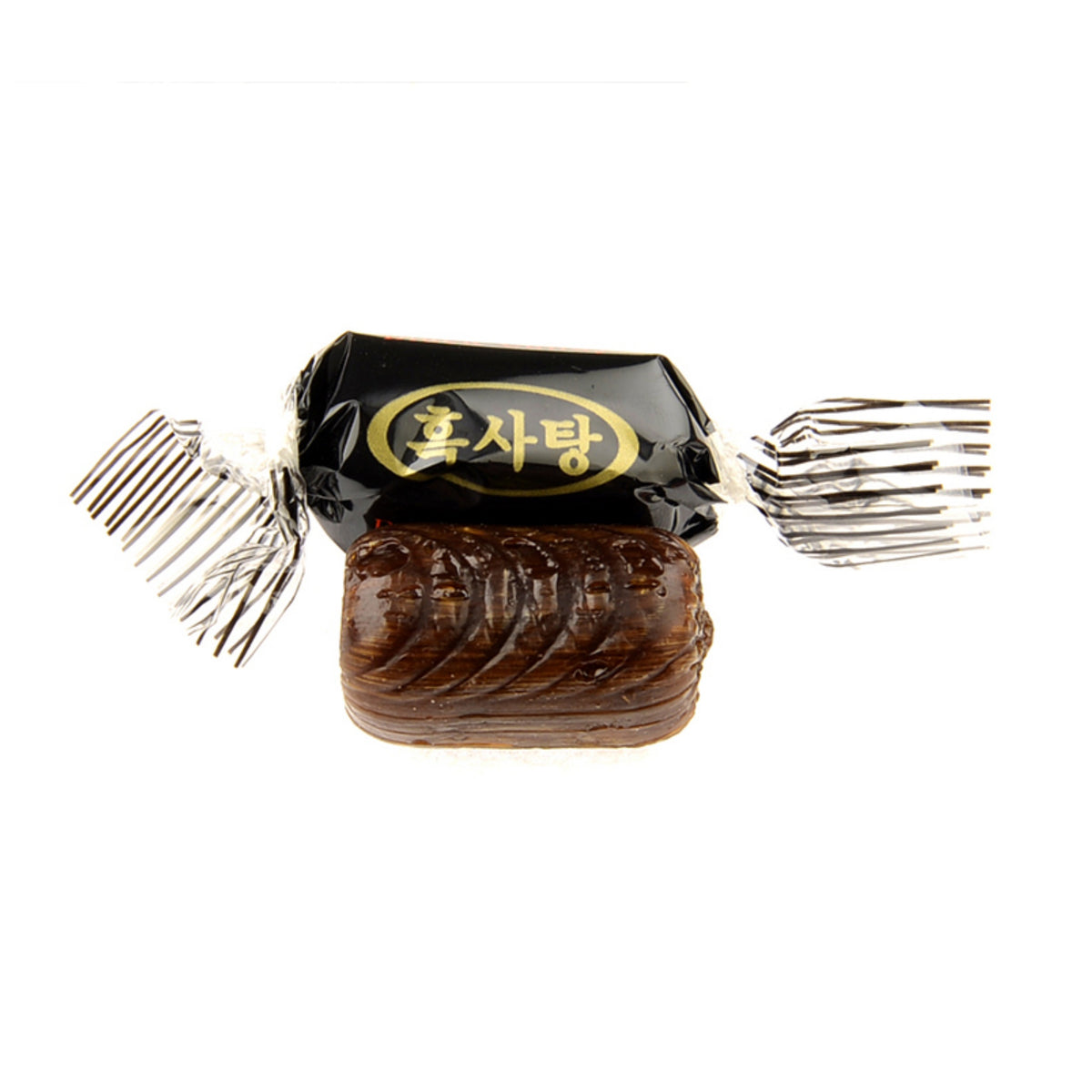 Korean black sugar candy — close-up of an unwrapped dark hard candy piece next to its wrapper