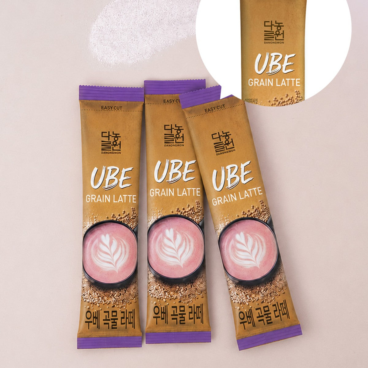 Three Korean ube grain latte sticks with easy-tear tops on a pale pink background